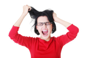 Woman stressed is going crazy pulling her hair in frustration.